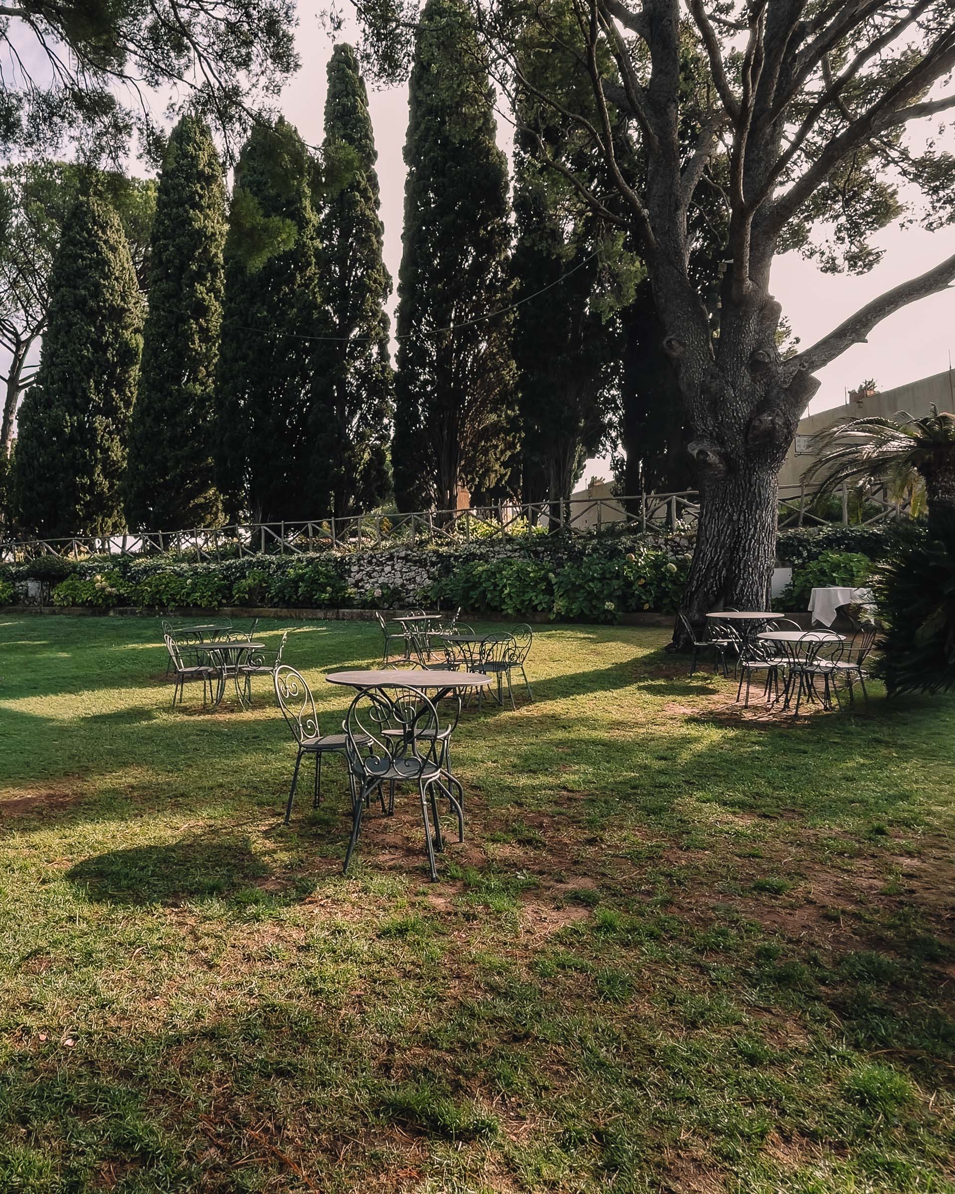 Tische und Stühle auf einer beschatteten Rasenfläche im Garten der Villa Cimbrone